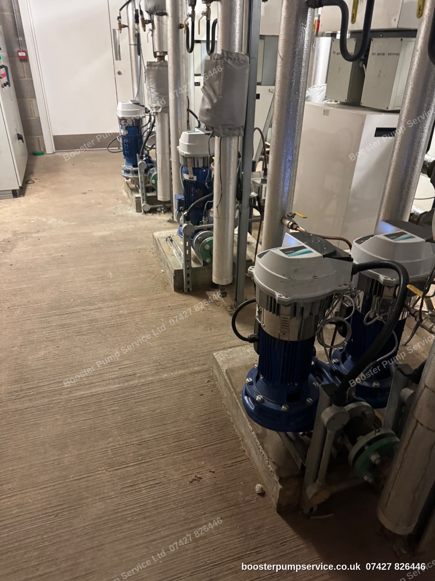 line-up of vertical multistage and twin-head pumps in a commercial plant room — inline pump replacement in London.